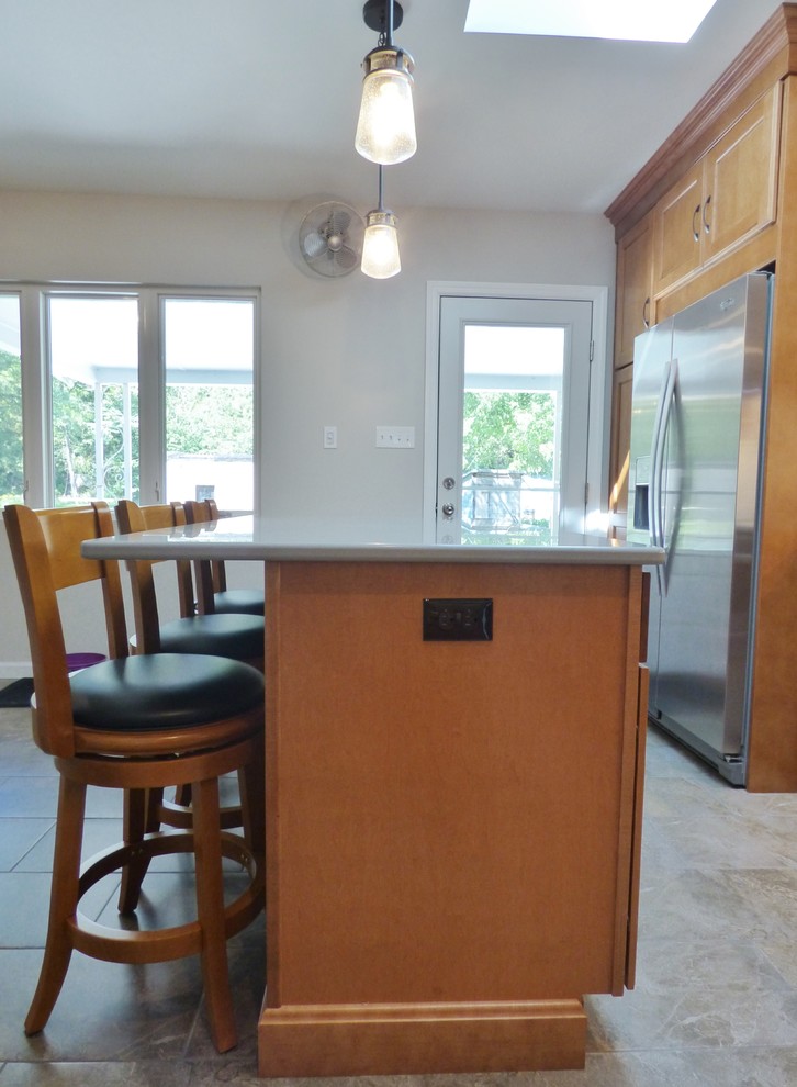 Inspiration for a transitional l-shaped porcelain tile eat-in kitchen remodel with an undermount sink, recessed-panel cabinets, medium tone wood cabinets, quartz countertops, white backsplash, subway tile backsplash, stainless steel appliances and an island