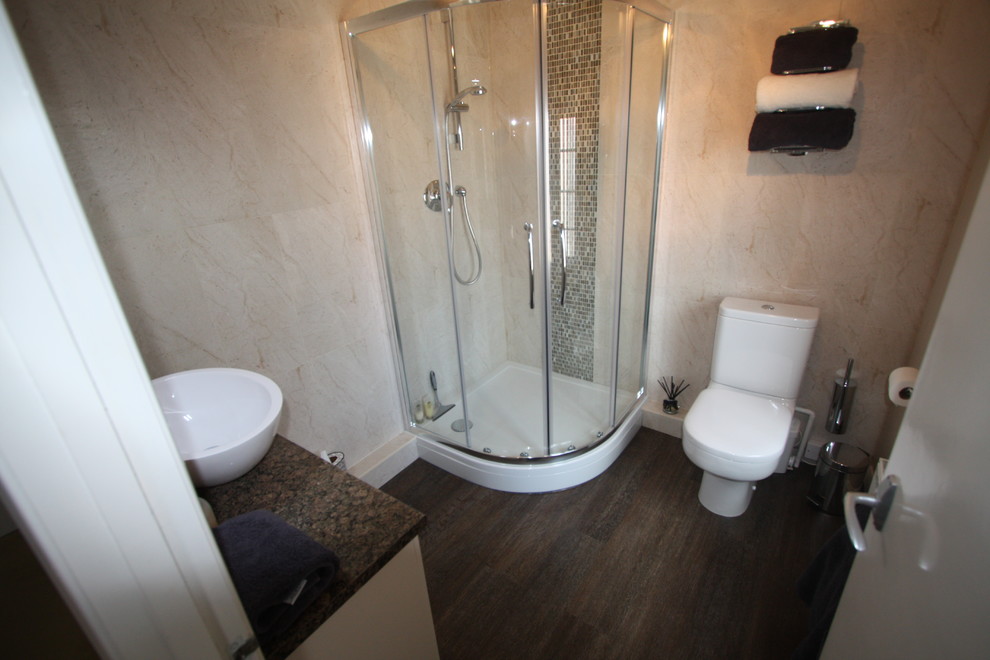 Immagine di una stanza da bagno padronale con lavabo sospeso, ante lisce, ante beige, top in laminato, doccia ad angolo, WC a due pezzi, piastrelle beige, piastrelle in ceramica, pareti beige e parquet scuro