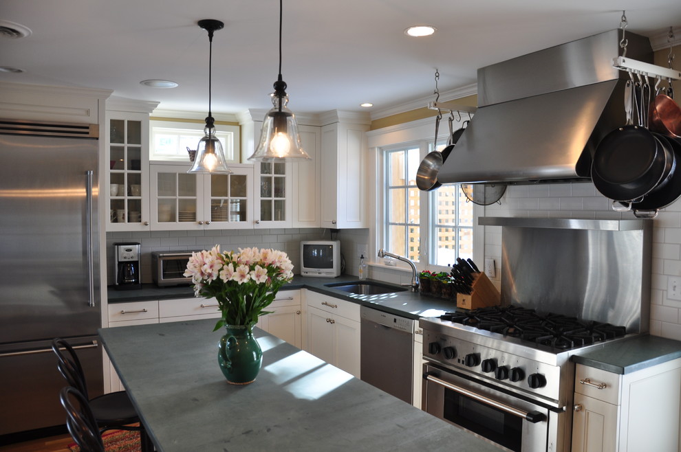 Eat-in kitchen - mid-sized transitional l-shaped medium tone wood floor eat-in kitchen idea in Boston with a drop-in sink, glass-front cabinets, white cabinets, limestone countertops, white backsplash, subway tile backsplash, stainless steel appliances and an island