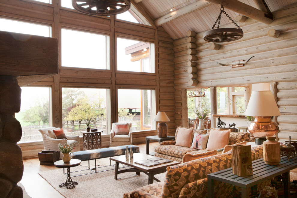 This is an example of a large country formal open concept living room in San Francisco with medium hardwood floors, brown walls, a standard fireplace, a stone fireplace surround and brown floor.