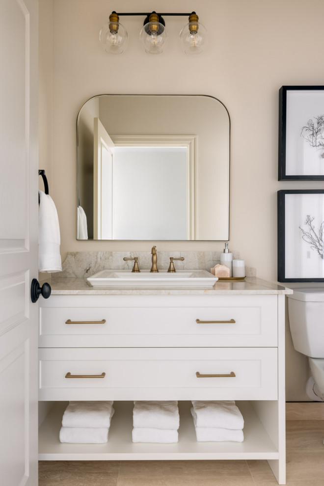 Cette photo montre une salle de bain chic de taille moyenne avec un placard à porte shaker, des portes de placard blanches, un carrelage beige, un mur beige, un sol en travertin, un lavabo posé, un plan de toilette en quartz modifié, un sol beige, un plan de toilette beige, meuble simple vasque et meuble-lavabo encastré.