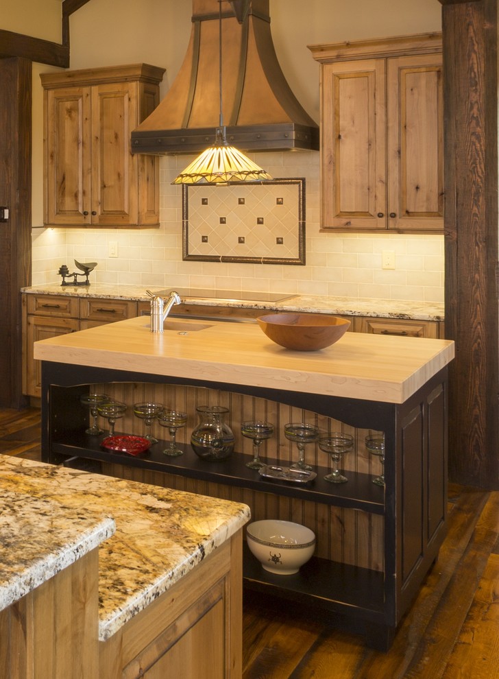 Example of a mountain style eat-in kitchen design in Denver with raised-panel cabinets, granite countertops and paneled appliances