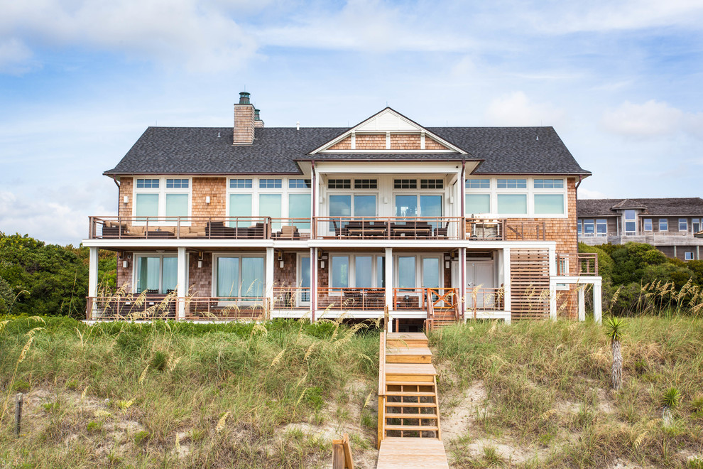 Inspiration for a large beach style two-storey brown house exterior in Other with wood siding, a gable roof and a shingle roof.