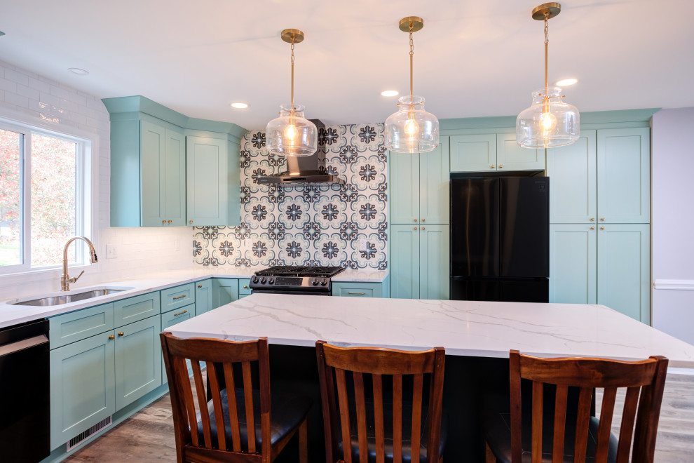 Medium sized contemporary l-shaped kitchen/diner in Raleigh with a single-bowl sink, shaker cabinets, turquoise cabinets, engineered stone countertops, white splashback, metro tiled splashback, stainless steel appliances, laminate floors, an island, grey floors and white worktops.