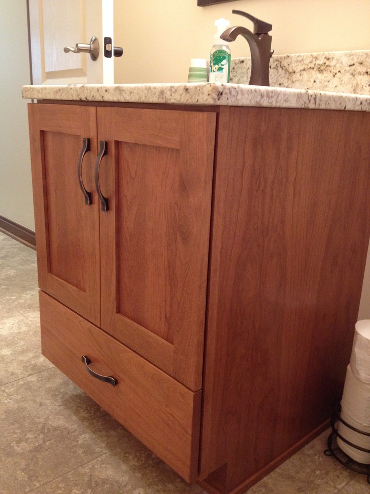 Small transitional beige tile powder room photo with an undermount sink, shaker cabinets, medium tone wood cabinets, granite countertops and beige walls