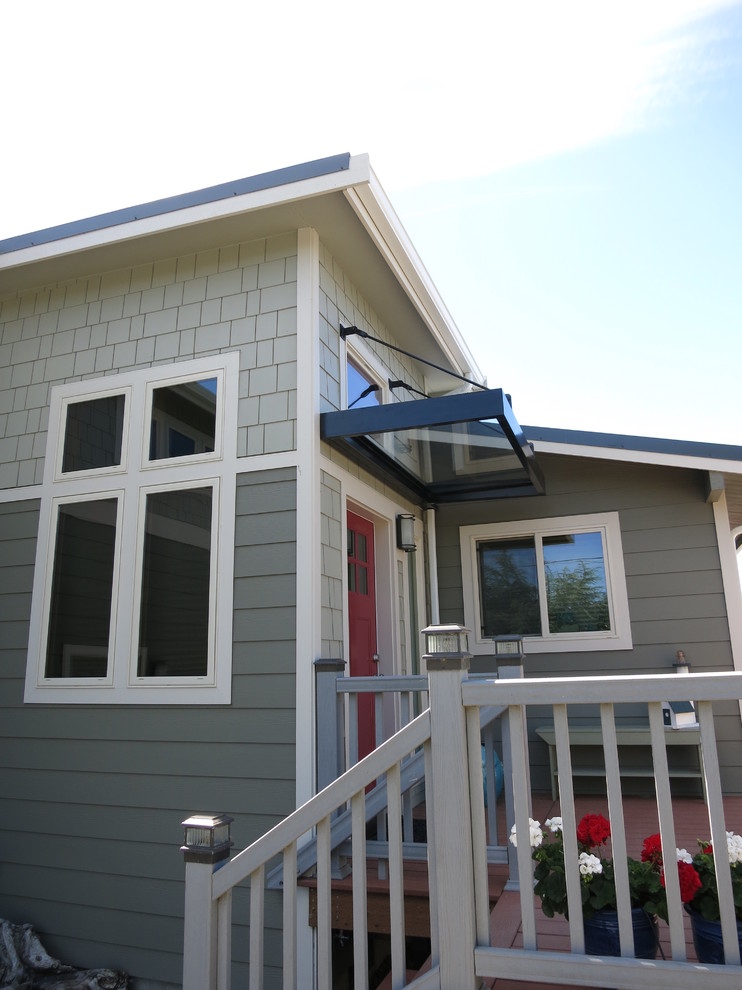 Mid-sized beach style two-storey grey house exterior in Seattle with concrete fiberboard siding, a gable roof and a shingle roof.