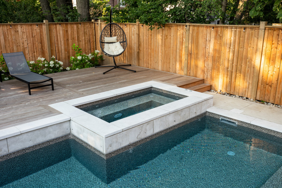 Inspiration for a mid-sized transitional backyard concrete and rectangular hot tub remodel in Toronto