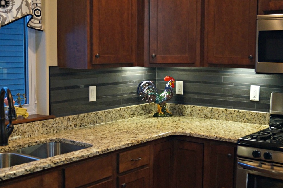 Mid-sized transitional u-shaped open concept kitchen photo in Cedar Rapids with a double-bowl sink, shaker cabinets, dark wood cabinets, granite countertops, black backsplash, porcelain backsplash, stainless steel appliances and an island