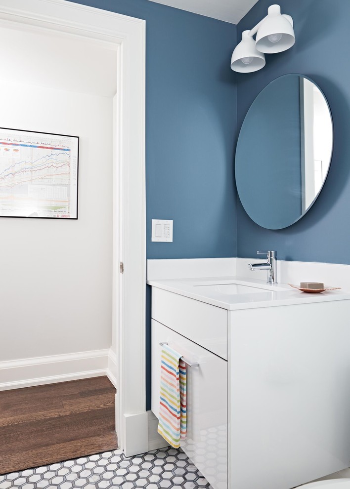 Design ideas for a mid-sized transitional 3/4 bathroom in Toronto with flat-panel cabinets, white cabinets, blue walls, cement tiles, an undermount sink and solid surface benchtops.