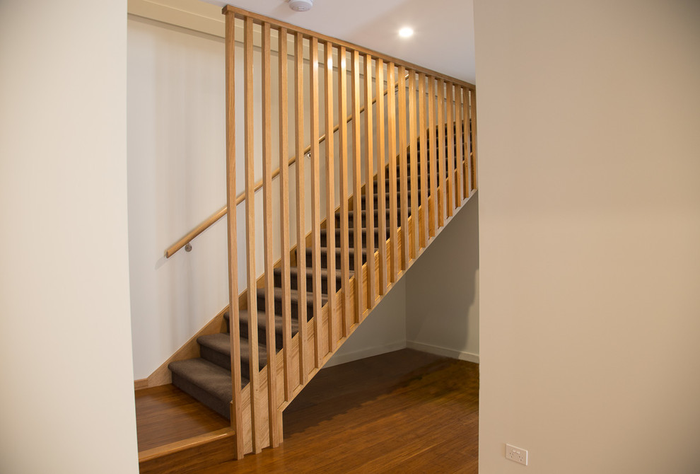 Design ideas for a mid-sized contemporary carpeted l-shaped staircase in Melbourne with wood railing.