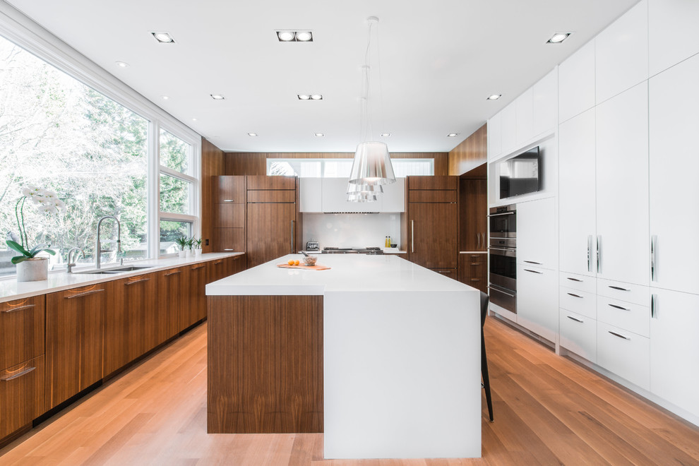 This is an example of a large contemporary u-shaped separate kitchen in Calgary with flat-panel cabinets, dark wood cabinets, white splashback, with island, an undermount sink, quartzite benchtops, glass sheet splashback, panelled appliances and laminate floors.