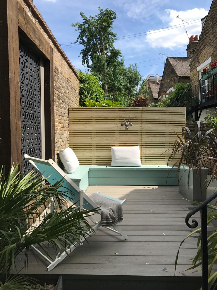 This is an example of a mid-sized contemporary side yard deck in London with no cover.