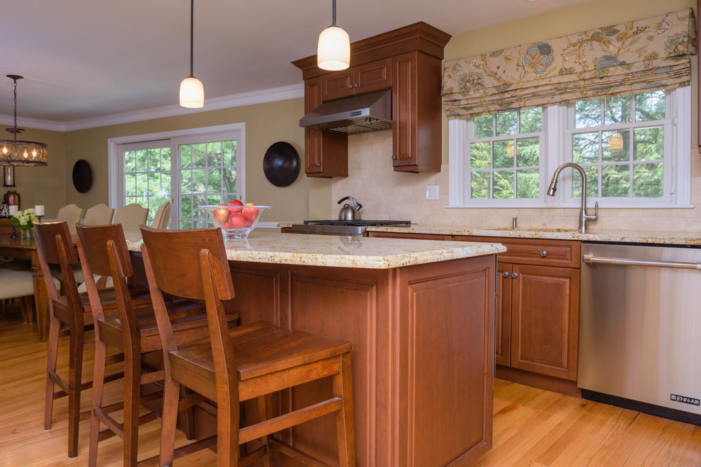 Small transitional l-shaped medium tone wood floor eat-in kitchen photo in Boston with raised-panel cabinets, medium tone wood cabinets, granite countertops, beige backsplash, subway tile backsplash, stainless steel appliances and an island