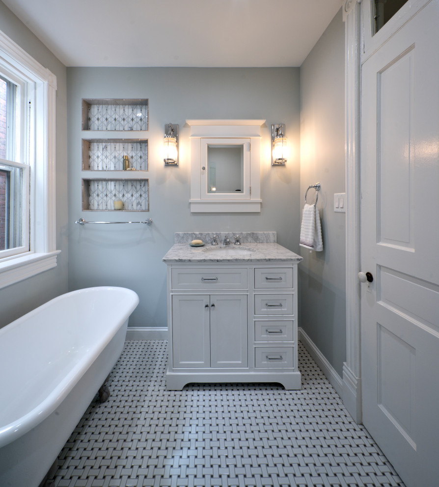 Idées déco pour une salle de bain principale victorienne de taille moyenne avec un placard à porte plane, des portes de placard blanches, une baignoire sur pieds, une douche d'angle, WC séparés, un carrelage gris, des carreaux de céramique, un mur gris, un sol en carrelage de céramique, un lavabo encastré, un plan de toilette en marbre, un sol blanc, une cabine de douche à porte battante, un plan de toilette blanc, une niche, meuble simple vasque et meuble-lavabo sur pied.