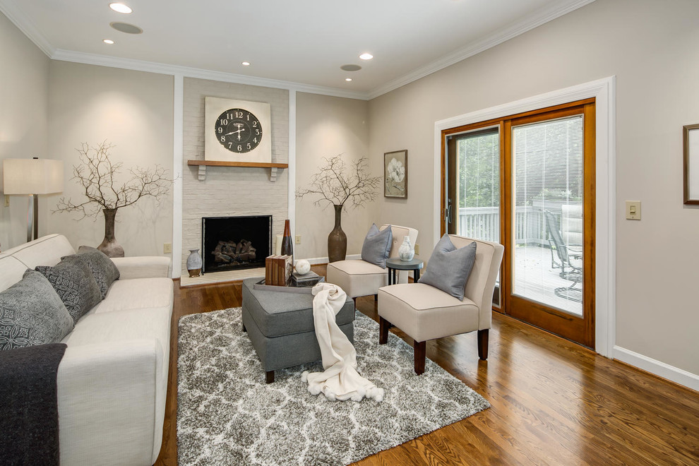 Inspiration for a traditional living room in DC Metro with grey walls, dark hardwood floors, a standard fireplace, a brick fireplace surround, no tv and brown floor.