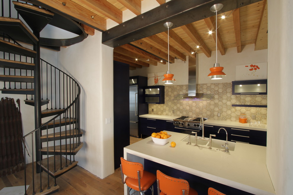 Example of a large transitional medium tone wood floor kitchen design in Phoenix with a farmhouse sink, flat-panel cabinets, blue cabinets, glass countertops and stainless steel appliances