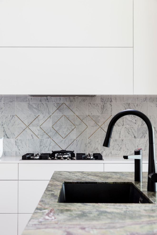 Bild på ett mellanstort funkis kök, med en undermonterad diskho, skåp i shakerstil, vita skåp, marmorbänkskiva, grått stänkskydd, stänkskydd i marmor, svarta vitvaror, mörkt trägolv, en köksö och brunt golv