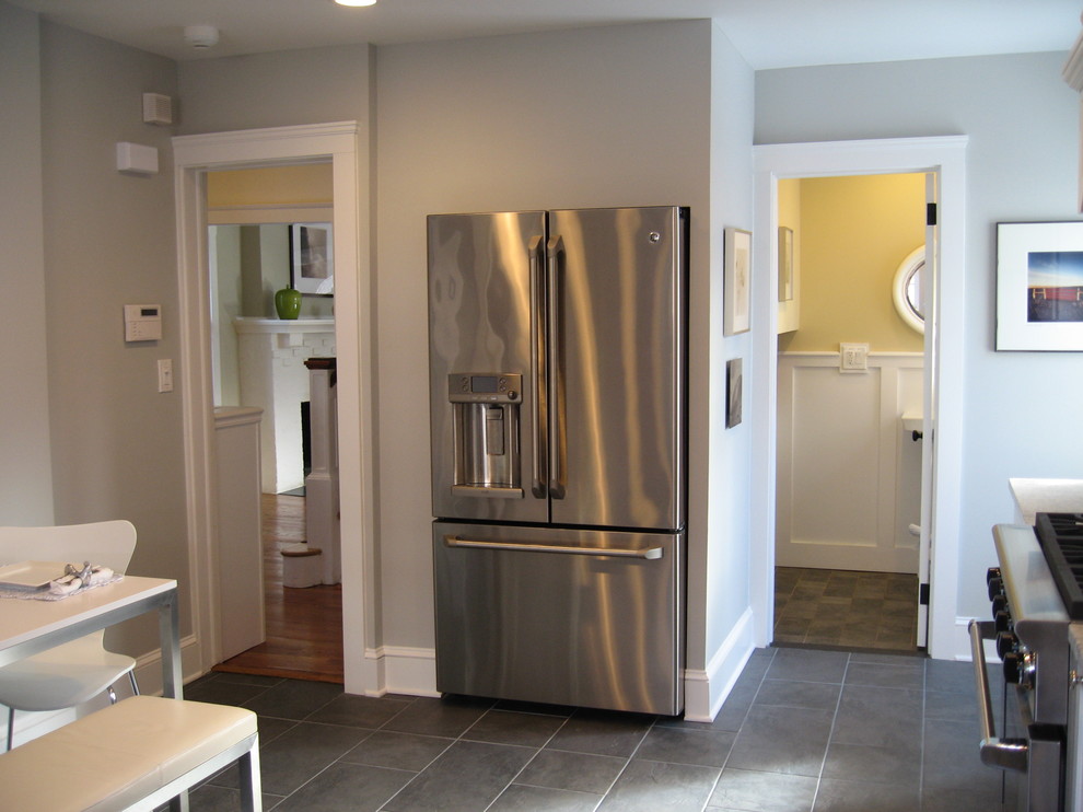 Inspiration for a transitional slate floor eat-in kitchen remodel in New York with a farmhouse sink, recessed-panel cabinets, white cabinets and paneled appliances