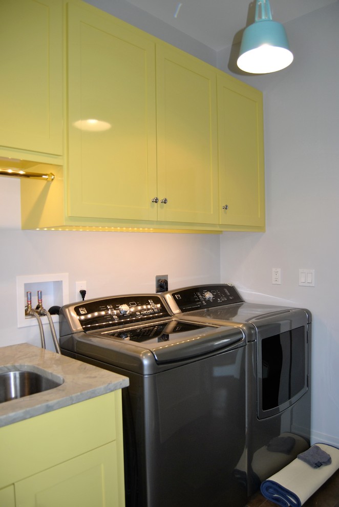 Inspiration for a small transitional single-wall dedicated laundry room in Boston with an undermount sink, flat-panel cabinets, yellow cabinets, granite benchtops, white walls and a side-by-side washer and dryer.