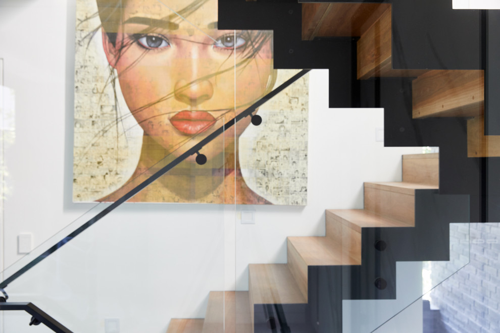 Imagen de escalera en U urbana grande con escalones de madera, contrahuellas de madera y barandilla de metal