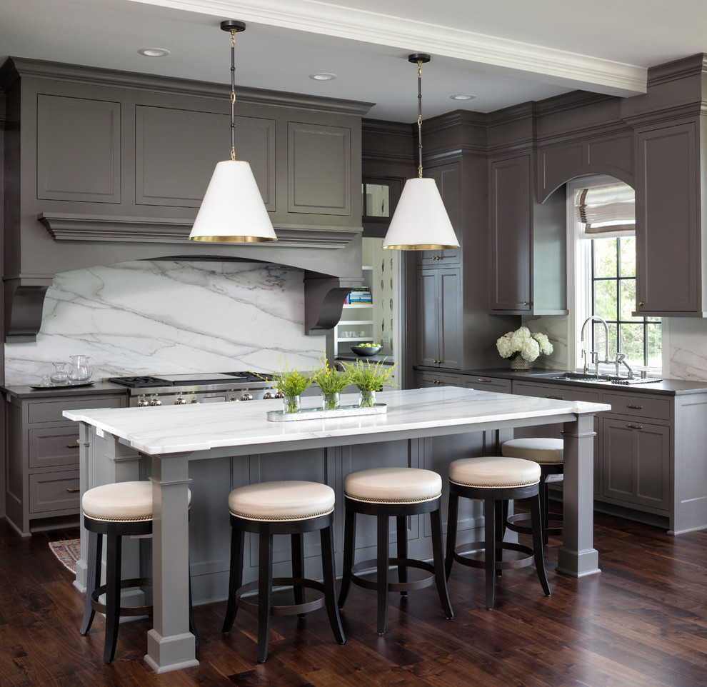 Inspiration for a traditional kitchen in Minneapolis with an undermount sink, shaker cabinets, grey cabinets, white splashback, marble splashback, stainless steel appliances, dark hardwood floors, with island, brown floor and white benchtop.