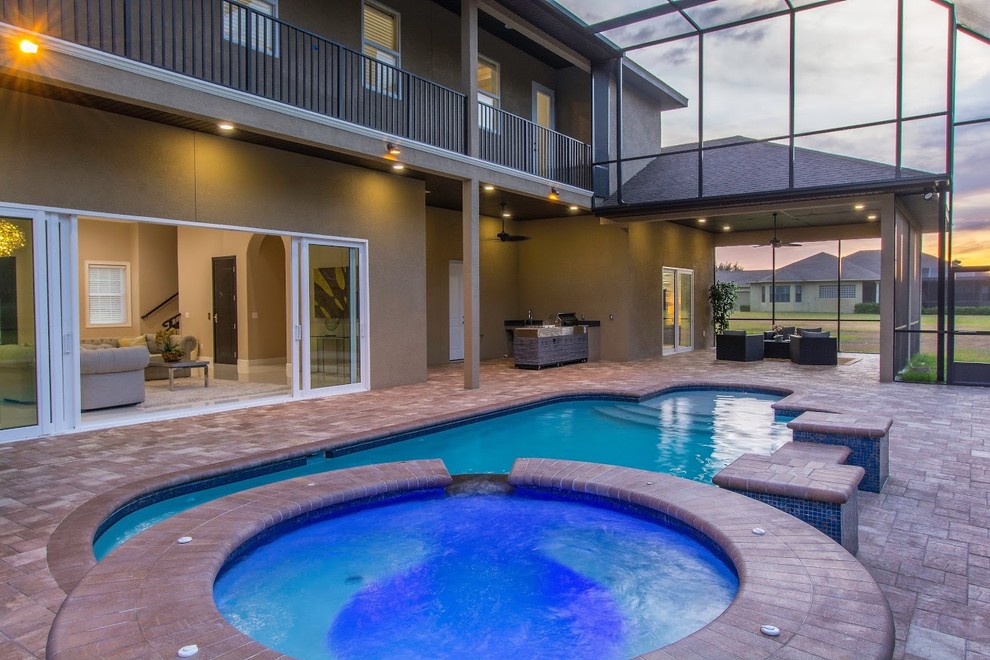 Large transitional indoor custom-shaped lap pool in Tampa with a hot tub and brick pavers.