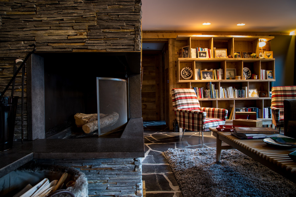 Photo of a country living room in Grenoble with a library, slate floors and a corner fireplace.