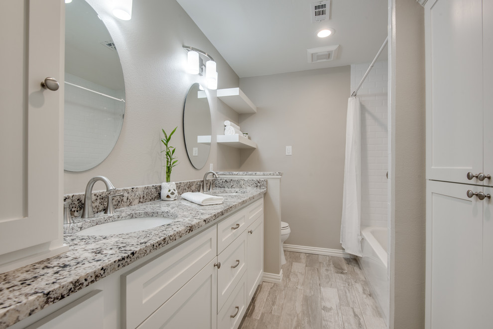 Inspiration for a transitional 3/4 bathroom in Dallas with recessed-panel cabinets, white cabinets, an alcove tub, a shower/bathtub combo, white tile, beige walls, an undermount sink, beige floor, a shower curtain and beige benchtops.