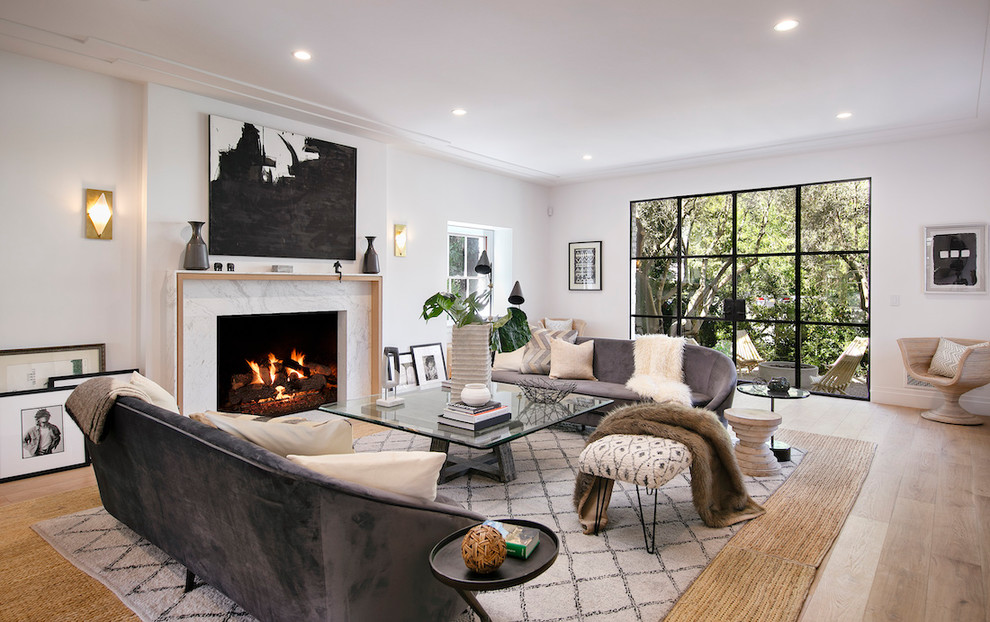 Design ideas for a beach style formal living room in Los Angeles with white walls, light hardwood floors, a standard fireplace, a stone fireplace surround and no tv.