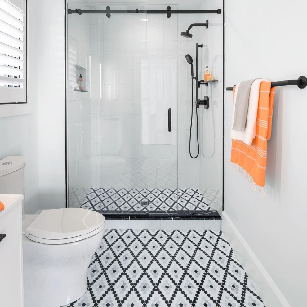 Ejemplo de cuarto de baño infantil, único y de pie, contemporáneo, pequeño, con puertas de armario blancas, ducha empotrada, sanitario de dos piezas, baldosas y/o azulejos blancos, baldosas y/o azulejos de cerámica, paredes blancas, suelo con mosaicos de baldosas, lavabo bajoencimera, suelo multicolor, ducha con puerta corredera, encimeras blancas y hornacina