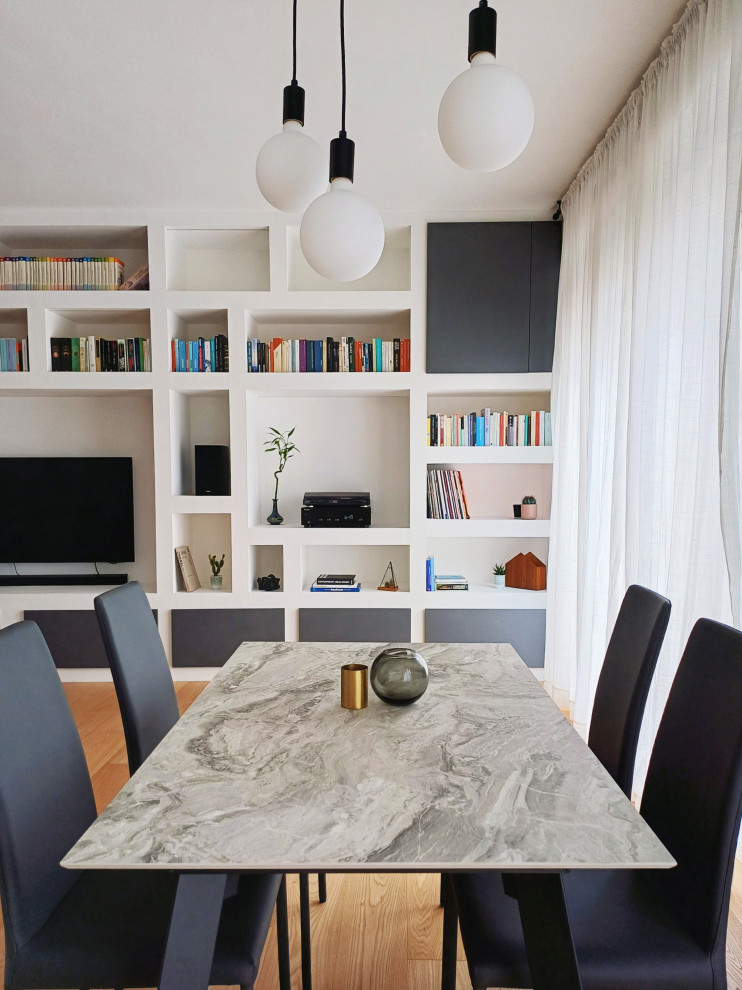 This is an example of a mid-sized scandinavian open plan dining in Milan with white walls and light hardwood floors.