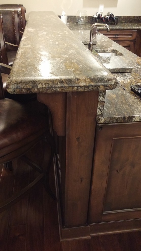 Example of a large transitional u-shaped medium tone wood floor home design design in Milwaukee with an undermount sink, raised-panel cabinets, brown cabinets, granite countertops and mirror backsplash