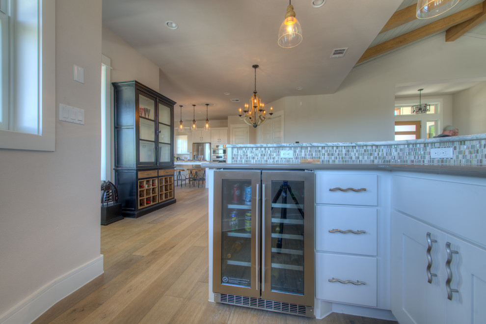 Example of a transitional eat-in kitchen design in Austin with stainless steel appliances and an island