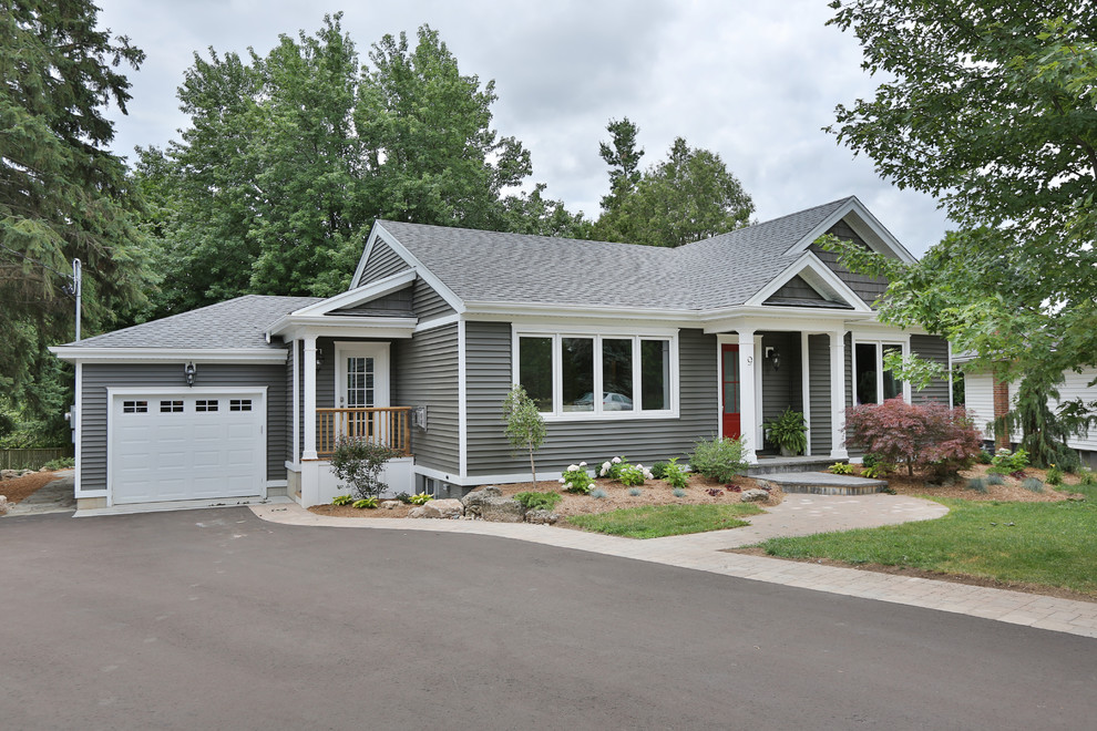 Photo of a mid-sized transitional one-storey grey house exterior in Toronto with vinyl siding and a shingle roof.