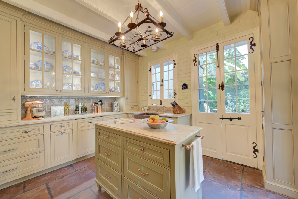 This is an example of a small traditional u-shaped separate kitchen in New Orleans with beaded inset cabinets, distressed cabinets, panelled appliances, terra-cotta floors and with island.