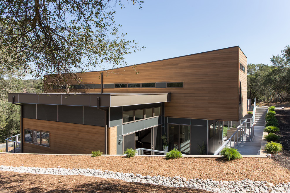 This is an example of a contemporary two-storey brown exterior in San Francisco with mixed siding and a flat roof.