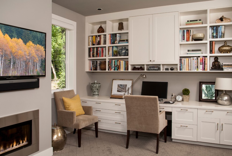 Design ideas for a mid-sized transitional study room in Seattle with grey walls, carpet, a standard fireplace, a metal fireplace surround, a built-in desk and beige floor.