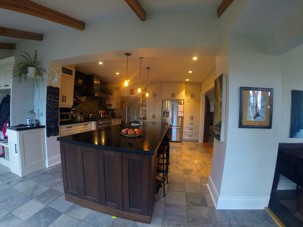 Example of a large transitional l-shaped ceramic tile eat-in kitchen design in Toronto with a single-bowl sink, shaker cabinets, white cabinets, solid surface countertops, multicolored backsplash, stainless steel appliances and an island