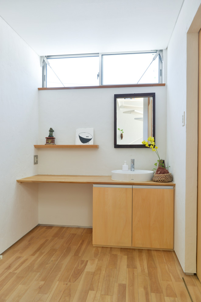 Cette photo montre un WC et toilettes moderne avec un mur blanc, un sol en bois brun, un plan de toilette en bois, un sol marron, un plan de toilette marron et un plafond en papier peint.