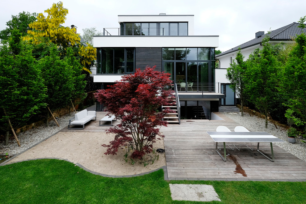 Contemporary three-storey white exterior in Hamburg with a flat roof and mixed siding.