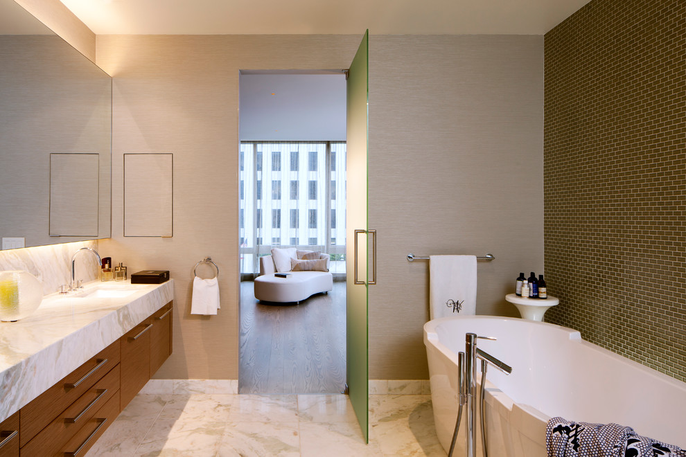Inspiration for a large contemporary master bathroom in San Francisco with flat-panel cabinets, a freestanding tub, a corner shower, a one-piece toilet, green tile, glass tile, marble floors, an undermount sink, marble benchtops, beige walls and medium wood cabinets.