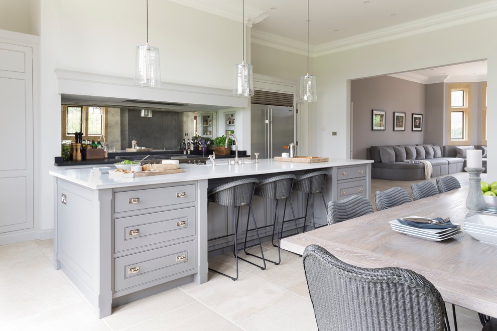 Inspiration for a large transitional galley open plan kitchen in Essex with with island, a double-bowl sink, metallic splashback, mirror splashback, stainless steel appliances, limestone floors, grey cabinets and quartzite benchtops.
