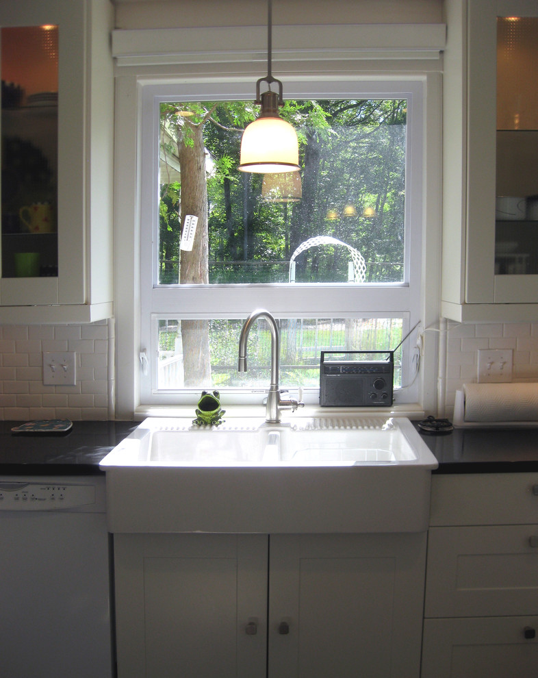 Design ideas for a transitional u-shaped eat-in kitchen in Milwaukee with a farmhouse sink, recessed-panel cabinets, white cabinets, quartz benchtops, white splashback, subway tile splashback and white appliances.