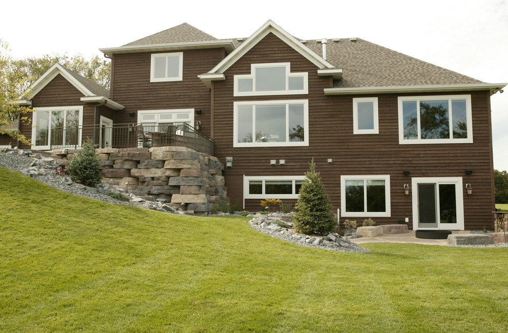 Photo of a mid-sized traditional two-storey brown exterior in Minneapolis with wood siding and a clipped gable roof.
