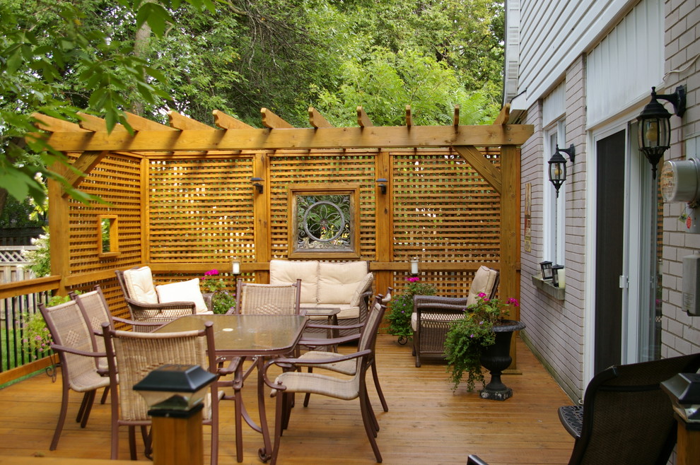 Mid-sized modern backyard deck in Montreal with a pergola.