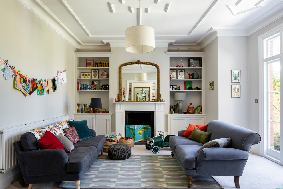 Design ideas for a large traditional open concept family room in London with a game room, grey walls, carpet, grey floor and a standard fireplace.