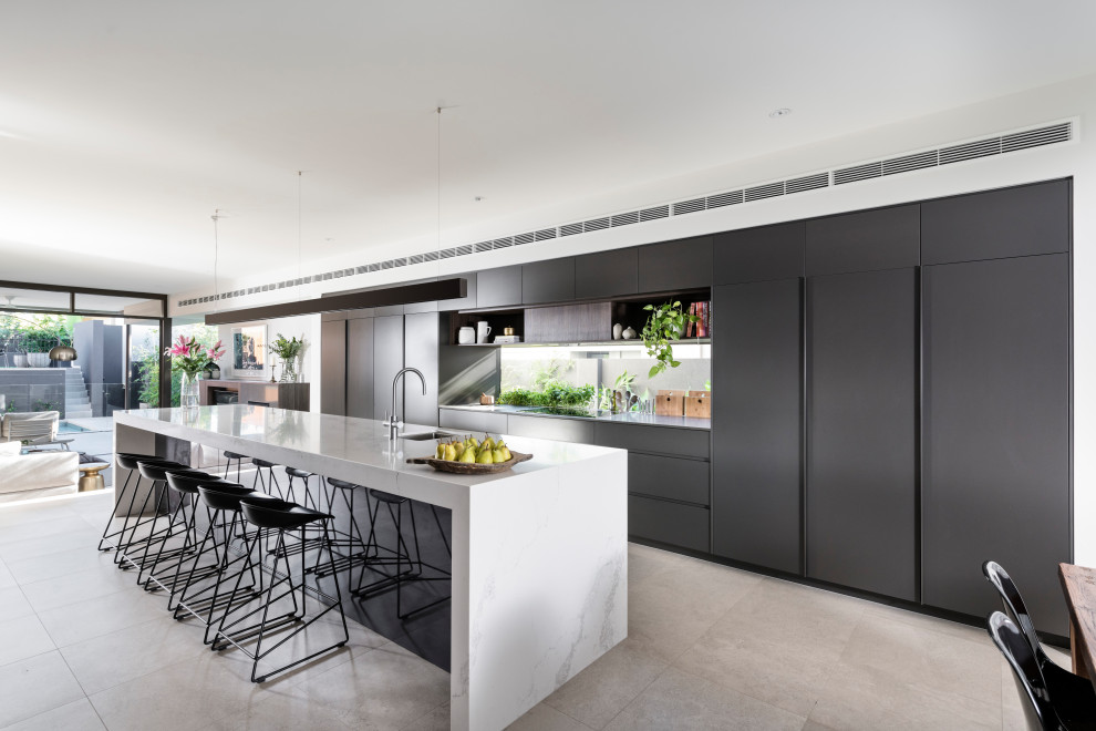 Photo of a large contemporary galley kitchen in Perth with an undermount sink, flat-panel cabinets, grey cabinets, window splashback, panelled appliances, with island, grey floor and grey benchtop.