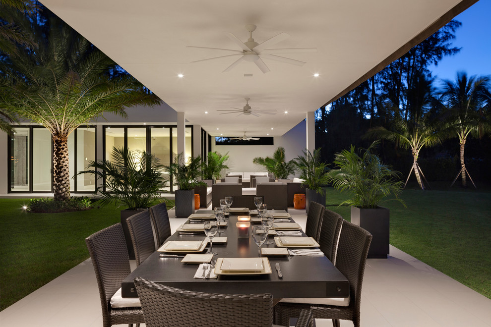 This is an example of a contemporary backyard patio in Miami with a roof extension.