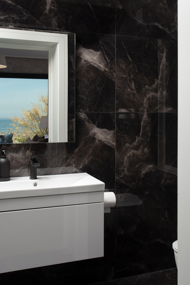 На фото: главная ванная комната в современном стиле с белыми фасадами, черной плиткой, мраморной плиткой, мраморным полом, черным полом, тумбой под одну раковину и подвесной тумбой с
