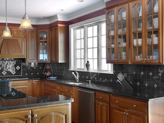 Kitchen - kitchen idea in Boston with a double-bowl sink, glass-front cabinets, medium tone wood cabinets, black backsplash and stainless steel appliances